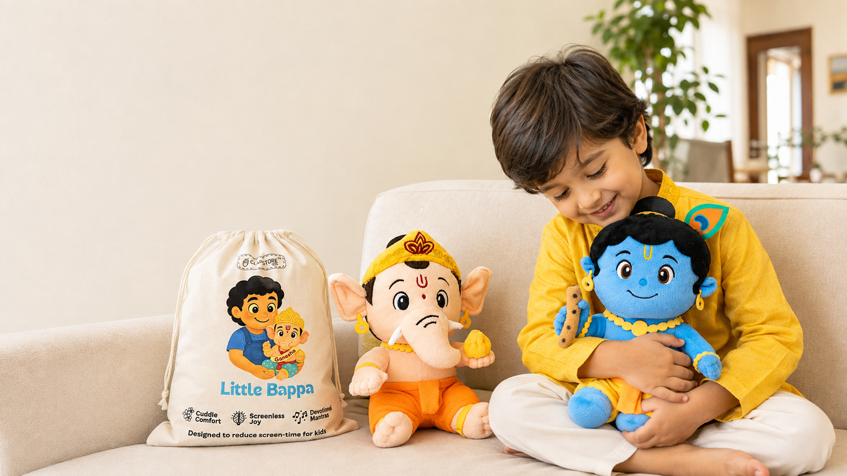 A grandmother and her granddaughter sitting together, the child holding a Clapstore mantra-chanting Ganesha plush while her grandmother guides her finger to the belly button